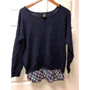 Navy blue sweater with plaid detail at bottom.